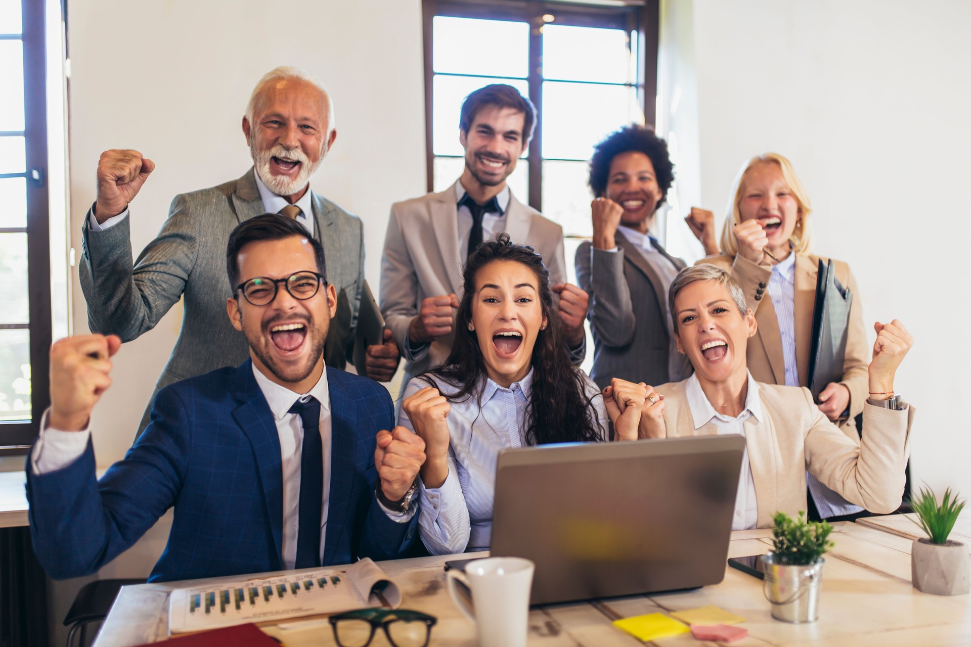 Happy business people celebrating success at company.