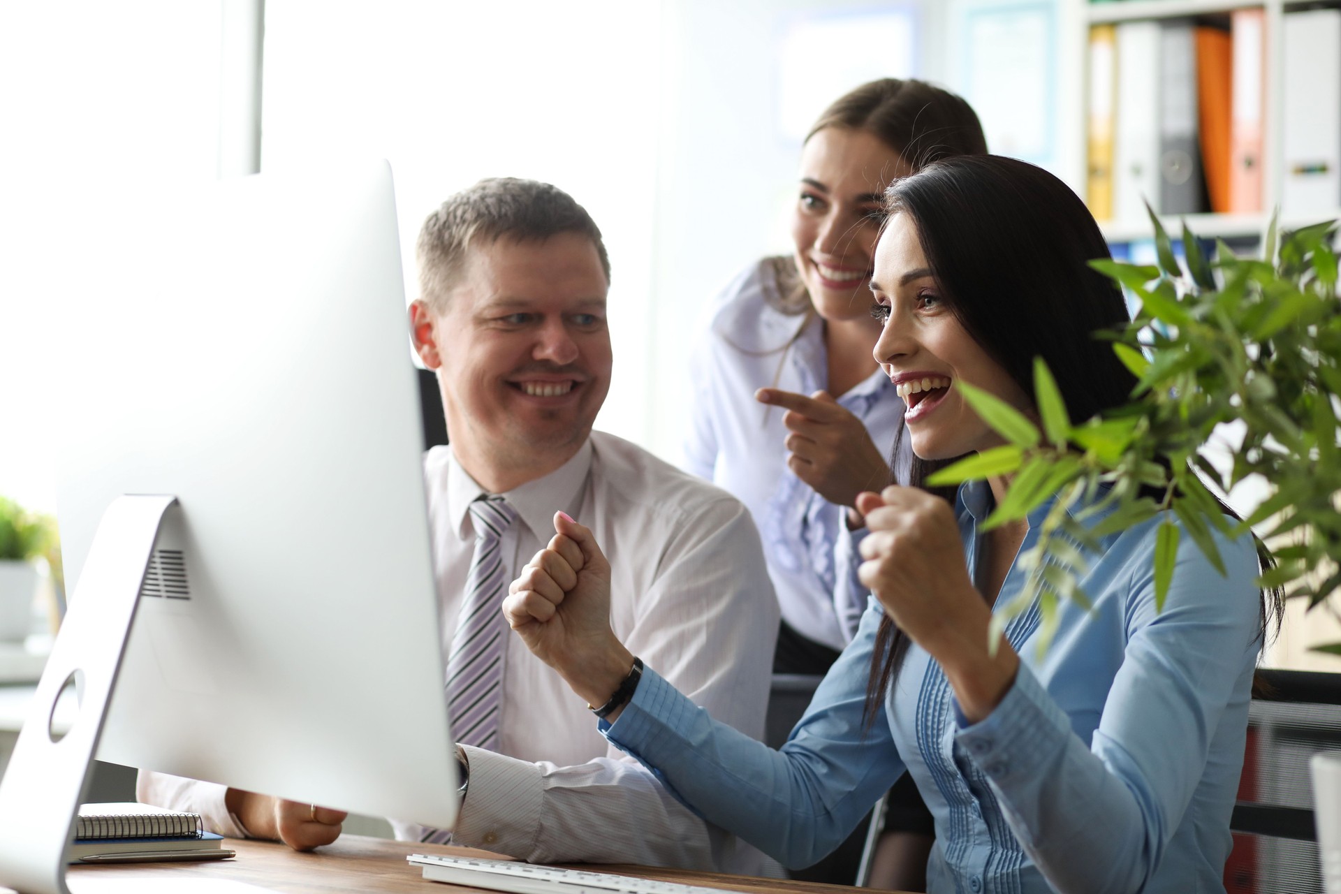 Group of people at office workplace watching show at computer display